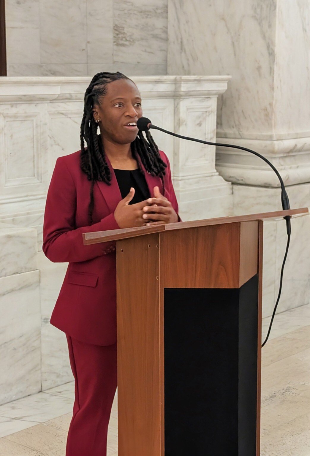 WVBF Founder and Executive Director Shekinah Apedo speaking at a podium inside the West Virginia State Capitol